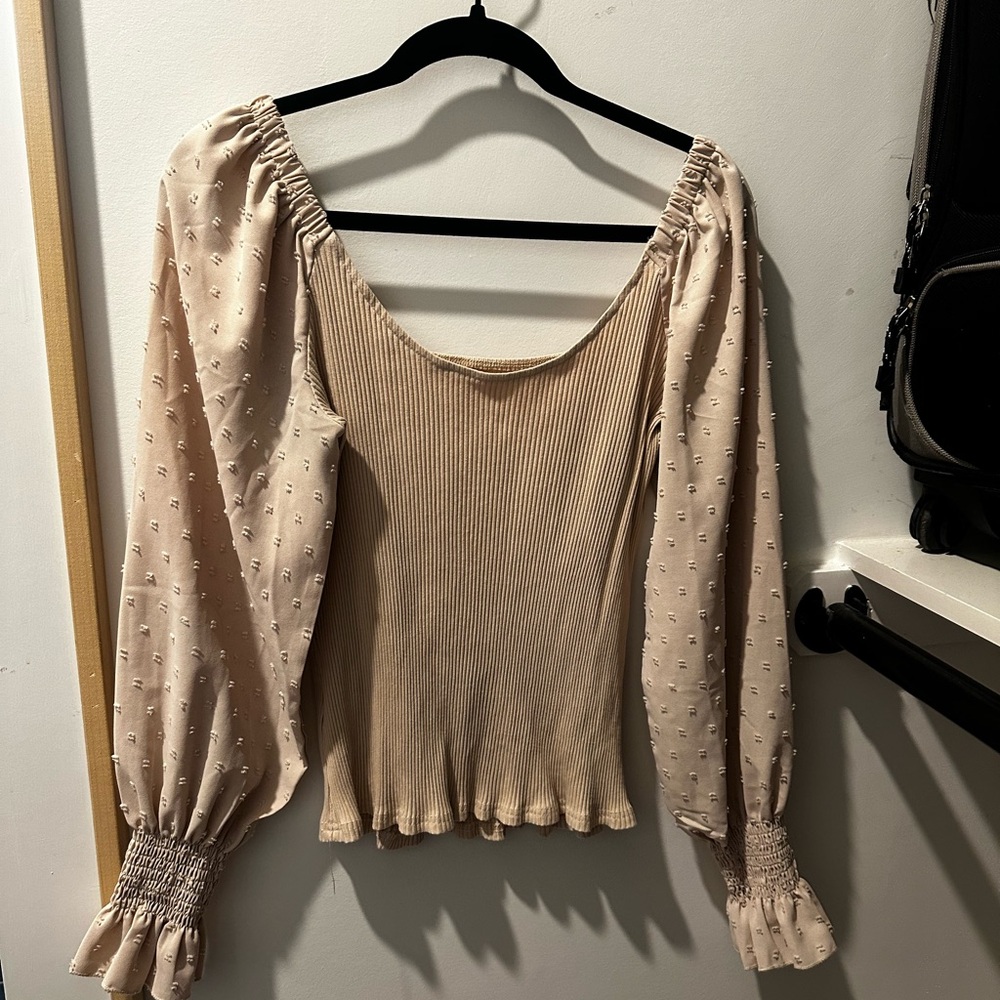 Small long sleeve blouse. Tight to body with puffy sleeves.